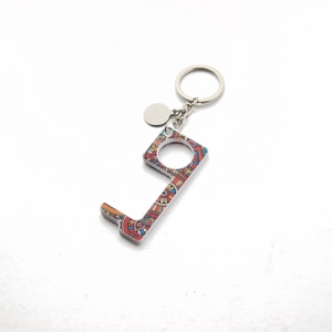 Macro detail of zero-touch acrylic keychain with bohemian pattern on white background