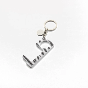 Detail of a black and white striped contactless door opener with metal key ring