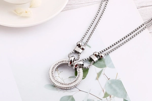 Detailed macro view of silver double-layer necklace with sparkling round crystal pendant