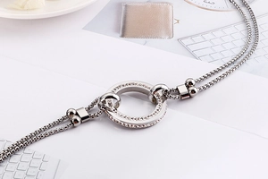 Close-up of double-layered silver titanium necklace featuring a sparkling rhinestone circle