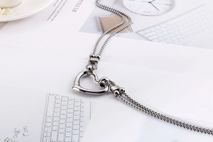 Detail of a stainless steel double-layered heart pendant necklace on a lifestyle magazine