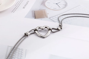 Detailed macro shot of silver double-layered heart pendant bracelet with slider clasp