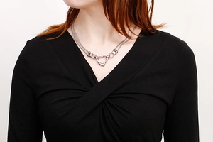 Close-up of double-layer silver heart necklace on neck, minimalist steel jewelry