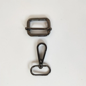 Détail de la boucle de réglage et du mousqueton pivotant en métal gris pour bandoulière