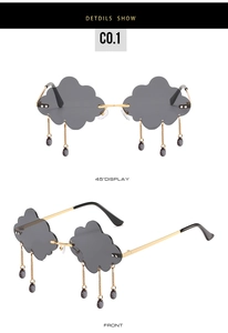 Close-up of grey cloud-shaped sunglasses with hanging teardrop beads and gold metal frame