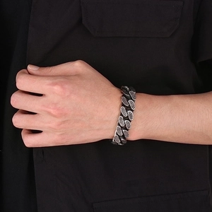 Close-up of vintage punk style dark metal Cuban chain bracelet on male model wrist