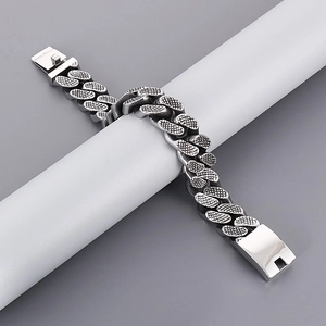 Macro detail of silver punk Cuban link bracelet with unique fish scale texture pattern