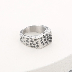 Detail of vintage hammered texture on wide stainless steel rectangular ring for men