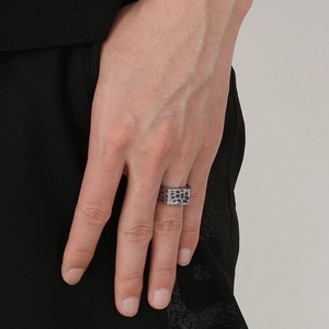 Macro detail of men's vintage stainless steel ring with a hammered texture on a finger