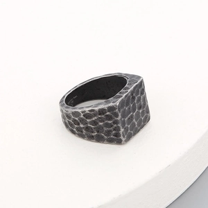 Macro detail of men's wide vintage stainless steel ring with hammered texture finish