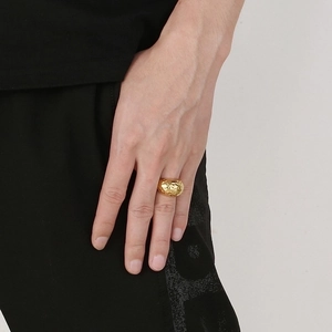 Close-up of a wide polished gold titanium ring with a hammered texture on a hand