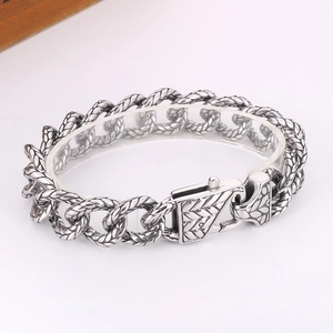 Macro detail of vintage punk silver titanium steel link bracelet with ornate woven patterns