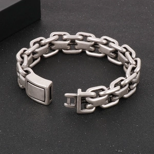 Detail of silver interlocking curb links and rectangular clasp on stainless steel bracelet