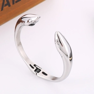 Close-up of a silver shark-shaped stainless steel bangle with spring hinge mechanism