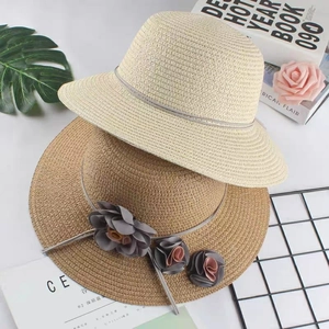 Foldable straw sun hat with decorative flowers in cream and tan for beach vacation
