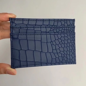 Close-up of navy blue crocodile pattern leather card holder with precise stitching
