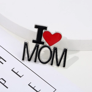 Silver I Love Mom brooch with red heart and black lettering on white pedestal