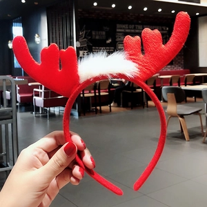 Close-up of a festive red reindeer antler headband with soft white plush fur detail