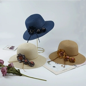 Detailed view of straw sun hats in navy, beige, and brown with 3D floral accents