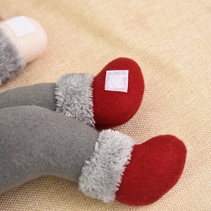 Christmas gnome curtain tieback featuring grey knit legs, red felt shoes, and velcro strap