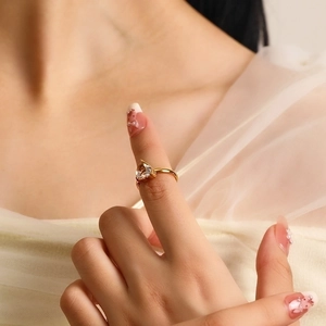 Close-up of elegant gold ring with a large heart-shaped zircon on a model's hand