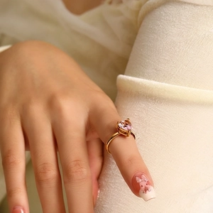 Close-up of heart-shaped pink zircon ring in 18k gold plating on a finger