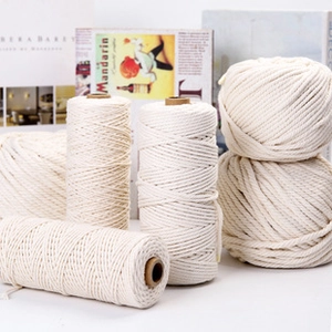 Close-up of cream white cotton rope rolls and balls showing fine braided texture for DIY