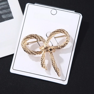 Golden bowknot brooch with braided texture on a fashion jewelry display card