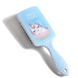 Close-up of blue cushion hairbrush with sleeping unicorn on donut and Enjoy and Dream text