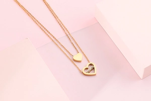 Close-up of gold double-layer necklace with mom heart pendant and sparkling crystal