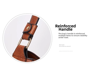 Detail of brown leather tote handle with gold D-ring hardware and reinforced stitching