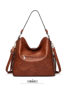 Detail view of the back of a vintage brown tote bag showing the metal zipper pocket