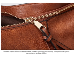 Detail of vintage brown oil wax leather bag featuring smooth golden metal zipper and stitching
