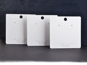Close-up of 7x7cm white square jewelry display cards for earrings and necklaces