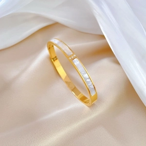 Golden titanium steel bangle featuring white shell inlay and sparkling crystal accents