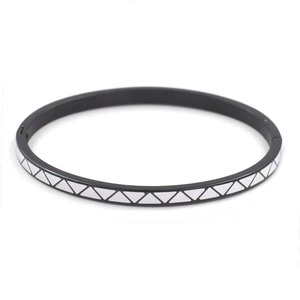 Macro detail of 4mm stainless steel bangle with black and white enamel geometric triangles