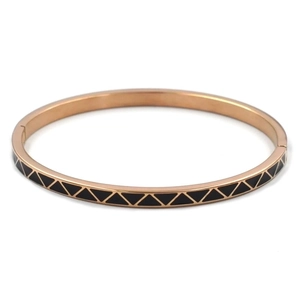 Macro detail of rose gold stainless steel bangle with black enamel triangle geometric patterns