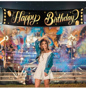 Close-up of Happy Birthday banner with black and gold stars and balloons decorations