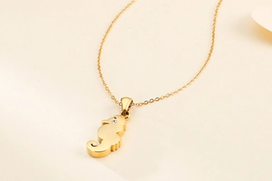 Dettaglio ravvicinato della collana con ciondolo a ippocampo dorato e piccolo diamante