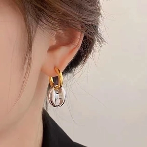 Two-tone brass earrings with 18K gold and silver link design shown on a female model