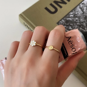Close-up of minimalist 925 sterling silver rings with white flower and star designs