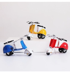 Drei Retro-Eisen-Motorroller in Rot, Blau und Gelb auf weißen Plattformen