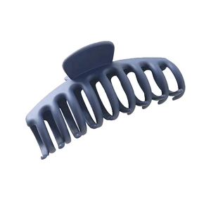 Detailed view of a large matte navy blue shark hair claw clip with a frosted texture