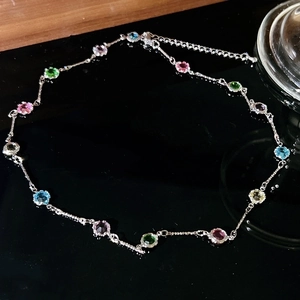 Macro detail of multi-colored round zircon necklace with adjustable silver chain