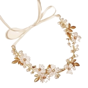 Close-up of handmade bridal headband with white ceramic flowers, pearls and golden leaves