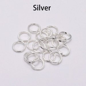 Macro shot of silver metal jump rings for DIY jewelry making on white background