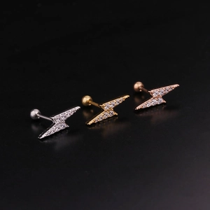 Macro shot of lightning bolt earrings in silver, gold and rose gold with zircon stones