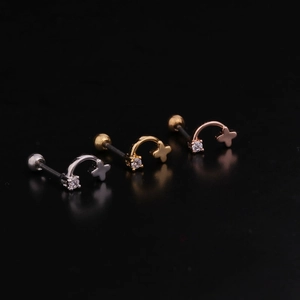 Detailed view of geometric stainless steel star ear studs in silver, gold, and rose gold