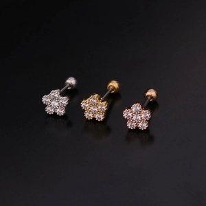 Three floral zircon stud earrings in silver, gold, and rose gold on black background