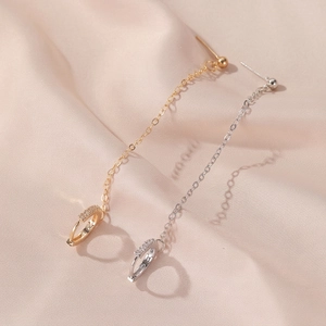 Elegant gold and silver long chain drop earrings with zircon studs on pink silk background